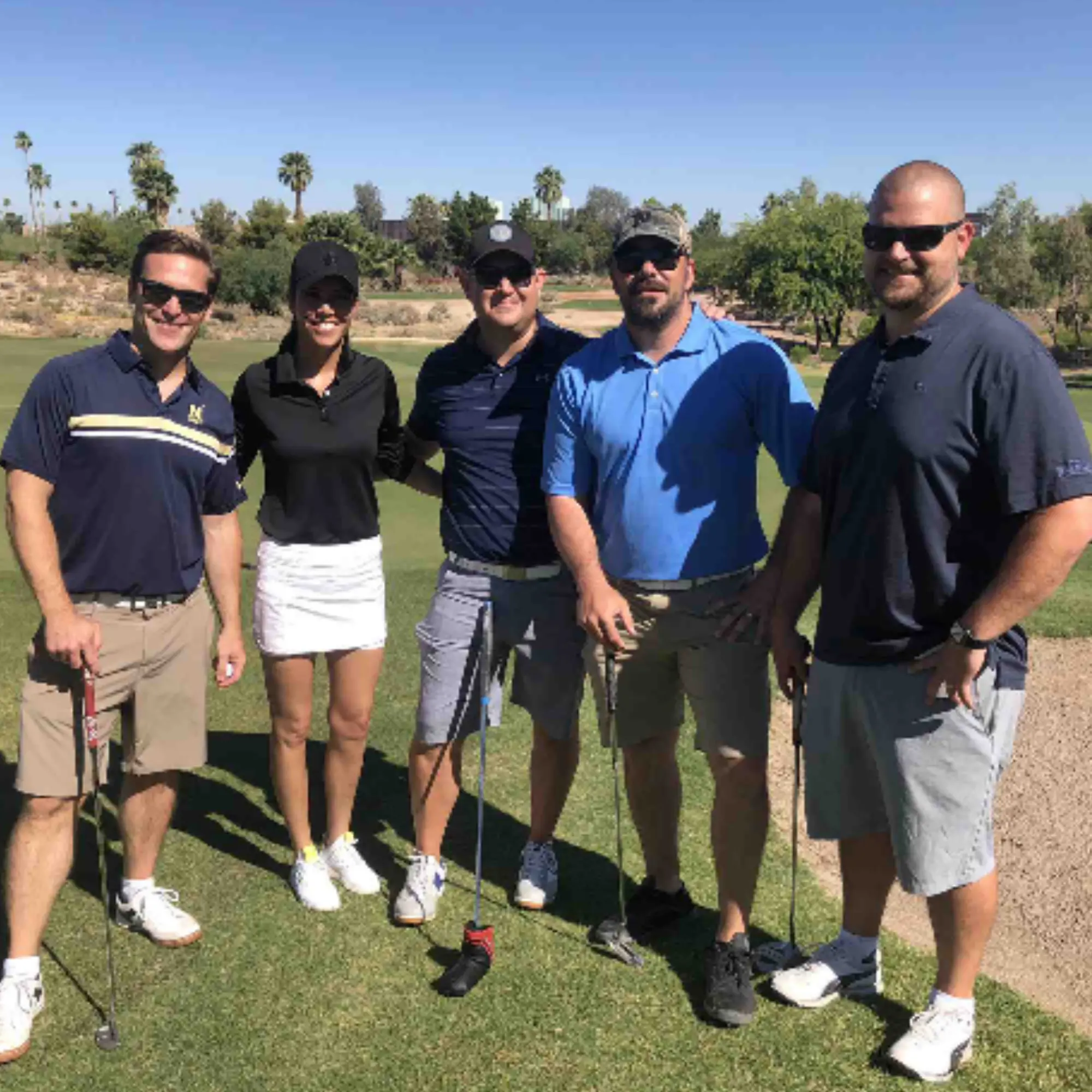 Five tournament participants posed at the tee box