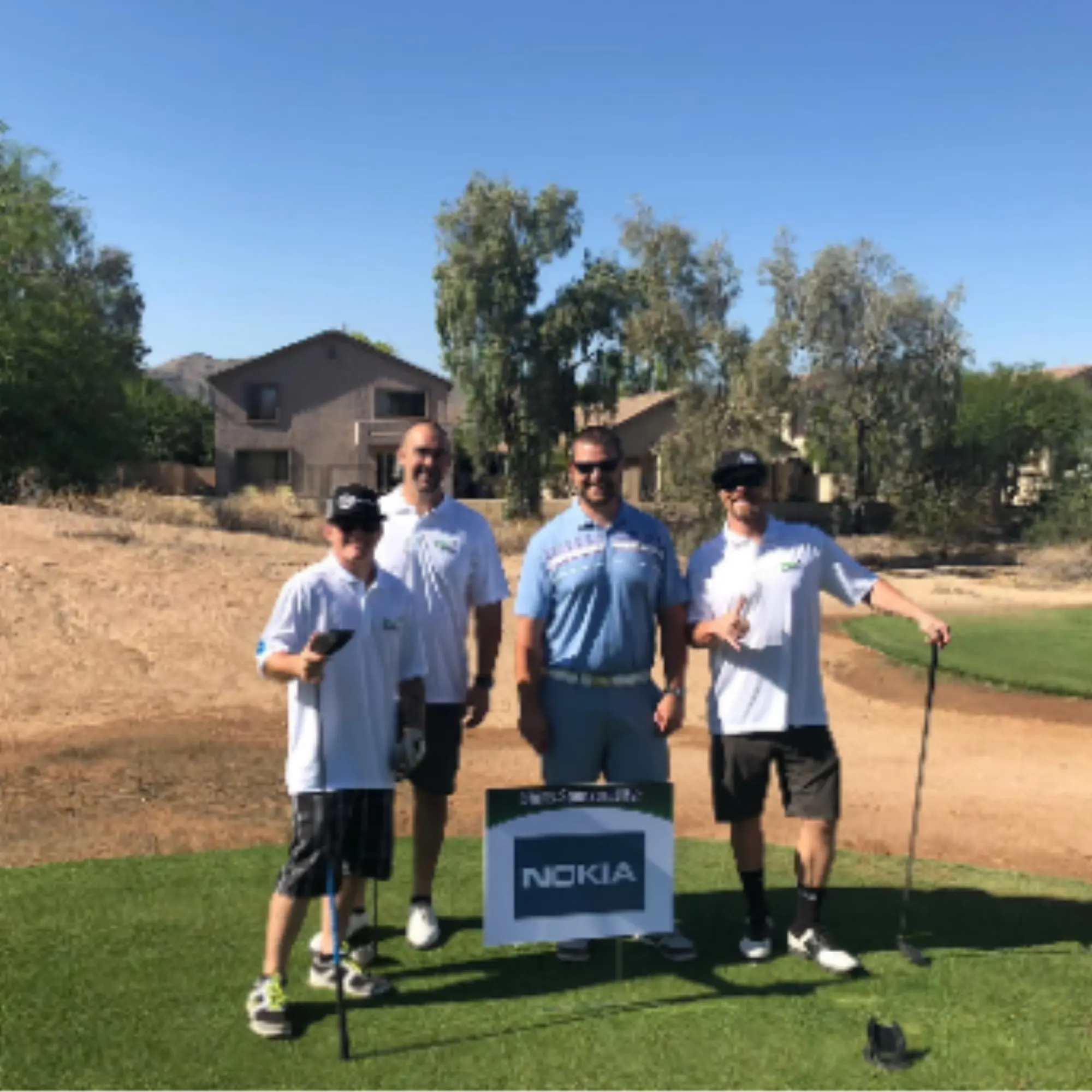 Four-person team posed at a tee box during the tournament