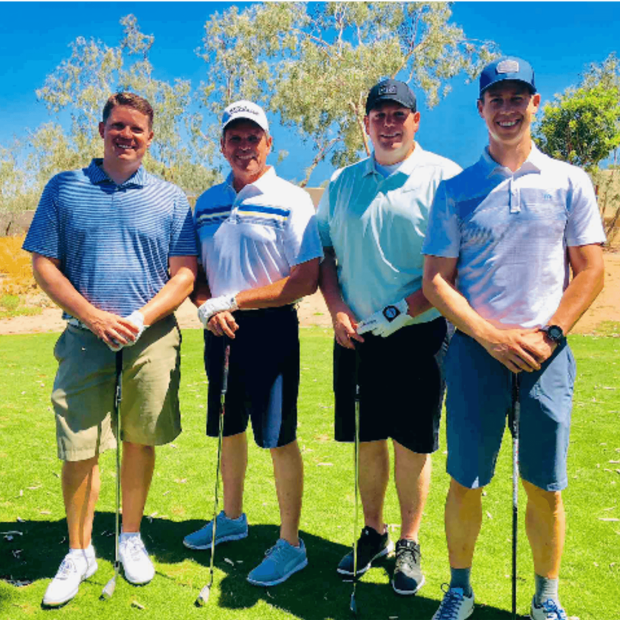 Four-person team posed together on the course with their putters