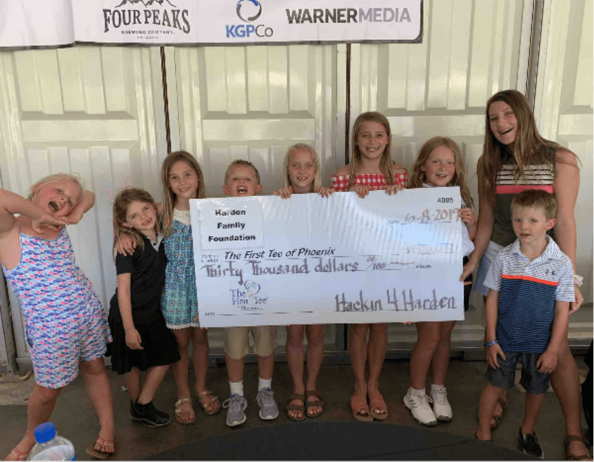 Children holding a giant ceremonial check from the Harden Family Foundation made out to The First Tee of Phoenix